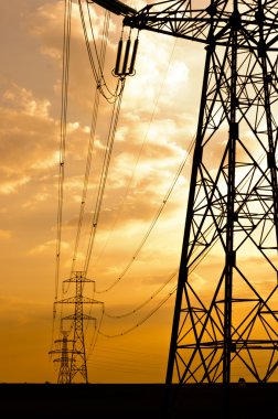 Angle shot of power lines against sunset in the background clipart