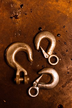 Rusty crane hooks on metal plate clipart