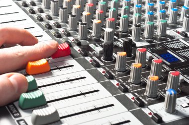 Closeup of an audio sound mixer with the hand of a man clipart