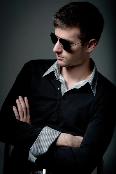 Jeune homme regardant du côté opposé portant des lunettes de soleil — Photo
