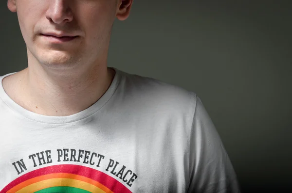 Zbliżenie człowieka z rainbow na koszuli i ciemnym tle — Zdjęcie stockowe