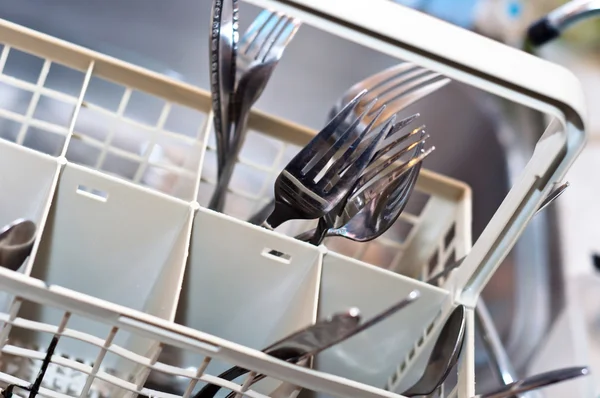 Forchette e coltelli in lavatrice con sfondo sfocato — Foto Stock
