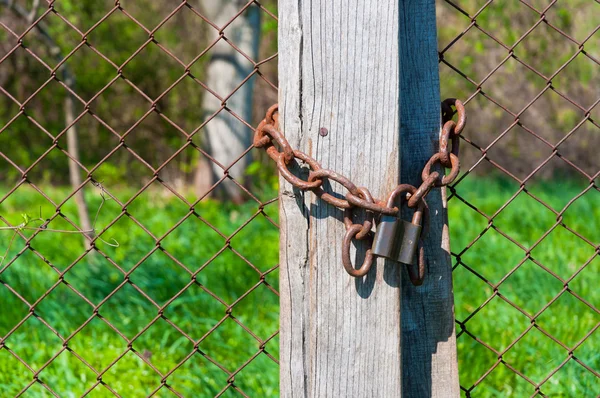 Old padlock with chains onb wooden fence — Stock Photo, Image