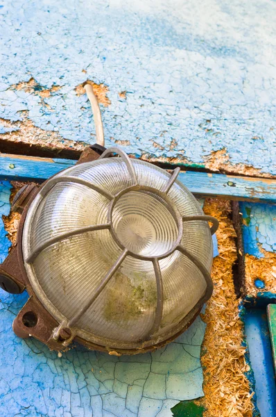 Старая и грязная лампа на голубой стене — стоковое фото