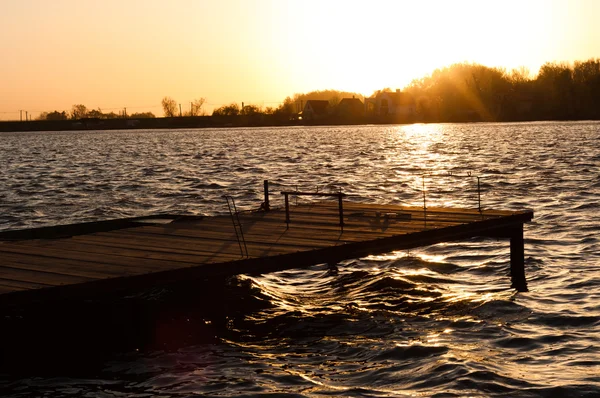 Molo na břehu s západ slunce — Stock fotografie