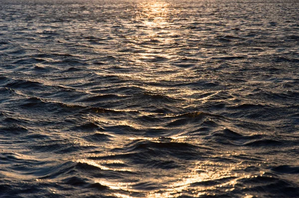 Ondas de água refletindo o pôr do sol — Fotografia de Stock