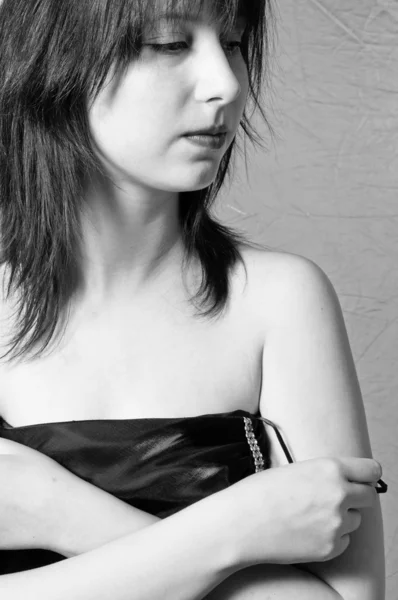 A beautiful young girl undressing in black and white — Stock Photo, Image