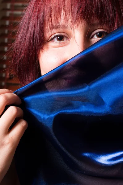 彼女の顔の前に青いスカーフを保持している女の子 — ストック写真