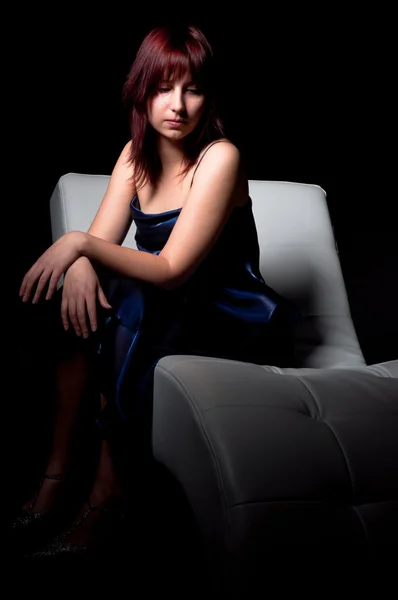Красивая женщина моды в синем платье сидя — стоковое фото