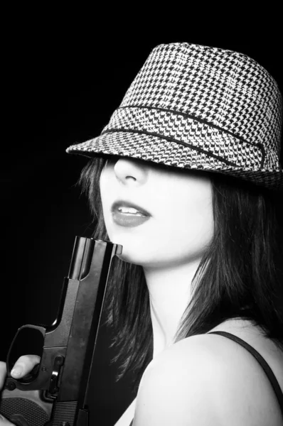 Beautiful young girl in hat holding pistol in black and white — Stock Photo, Image