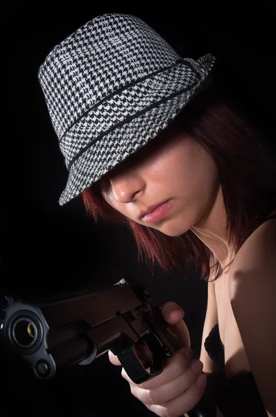 Girl with hat pointing gun — Stock Photo, Image