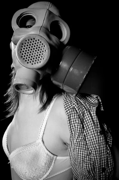 Menina em máscara de gás e lingerie contra fundo preto em preto a — Fotografia de Stock
