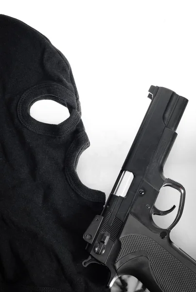 Pistol and mask of a thief over white — Stock Photo, Image