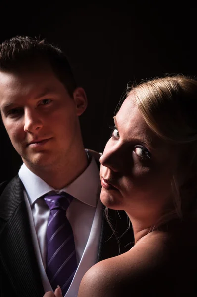 Ženich a nevěsta proti tmavému pozadí — Stock fotografie
