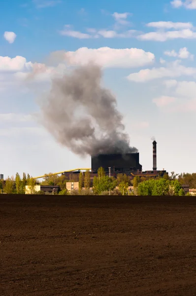 Темный дым, поднимающийся с электростанции на голубом фоне — стоковое фото