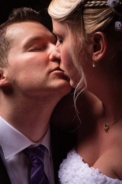 Jeune couple en tenue de mariage baisers — Photo