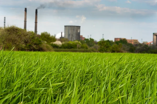 stock image Green field with Industry in the background polluting our beauti