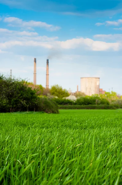 Fresh green grass with nuclear power plant and blue sky — Stock Photo, Image