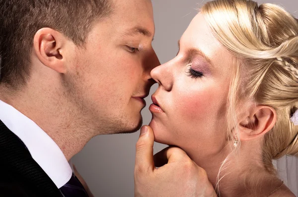 Junges Paar in Hochzeitskleidung küsst — Stockfoto
