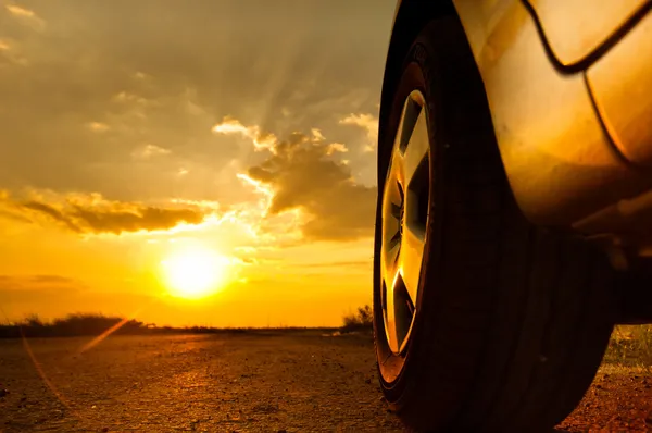 Zblízka střílel z auta proti západu slunce v pozadí — Stock fotografie