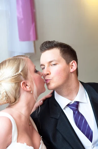 Knappe bruidegom kussen haar bruid — Stockfoto