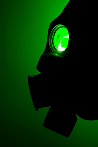 Silhouette einer Gasmaske im grünen Licht — Stockfoto