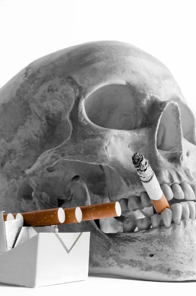 Skull with burning cigarette in mouth — Stock Photo, Image