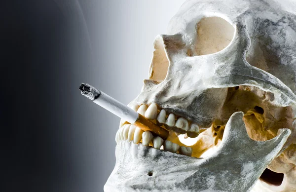 मुंह में जलते सिगरेट के साथ खोपड़ी — स्टॉक फ़ोटो, इमेज
