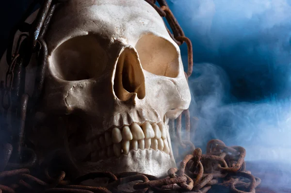 Cráneo humano con cadena y humo — Foto de Stock