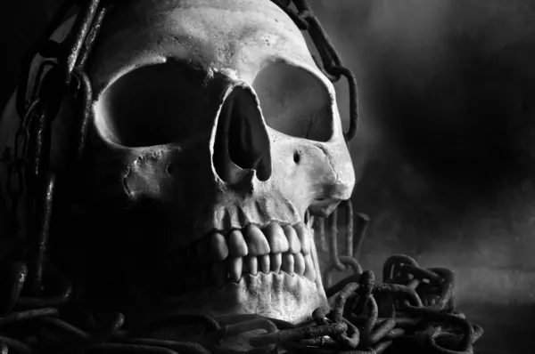 Menselijke schedel met ketting en rook in zwart-wit — Stockfoto