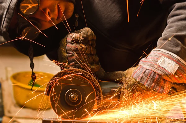 Werknemer snijden metaal met veel scherpe vonken — Stockfoto