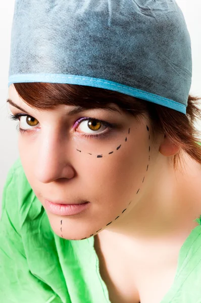 顔のプラスチック su のマークとして若い女性の顔に線を描画 — ストック写真