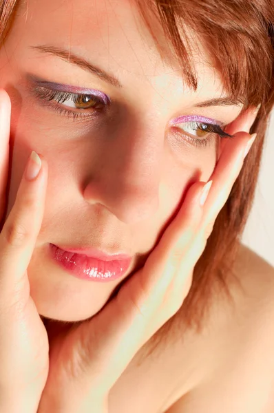 Close-up de uma jovem mulher segurando o rosto com as mãos — Fotografia de Stock