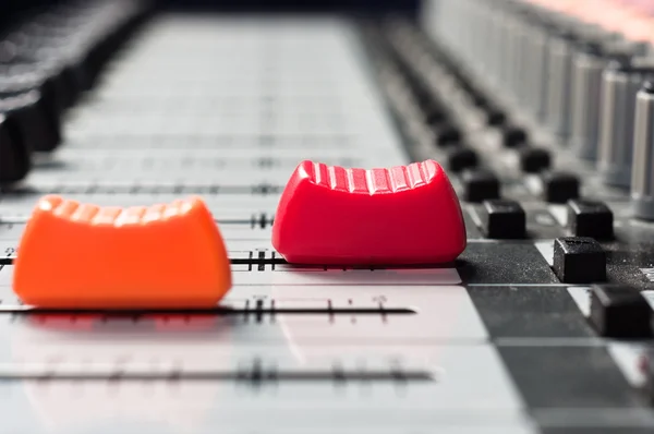 Control deslizante naranja y rojo en un mezclador de sonido — Foto de Stock