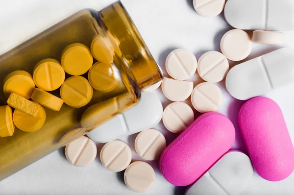 Garrafa de medicina com pílulas contra fundo branco — Fotografia de Stock