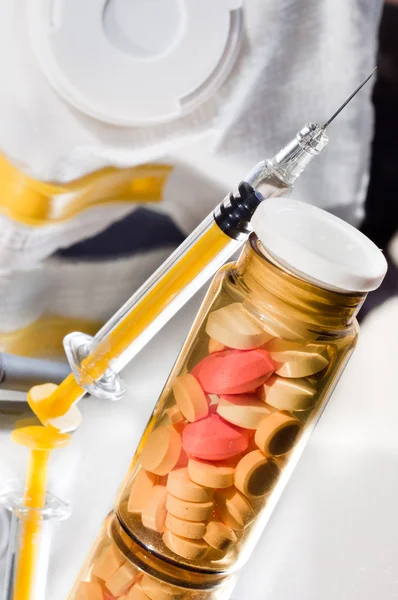 Frasco de vidrio medicinal con pastillas y jeringa con mascarilla protectora —  Fotos de Stock
