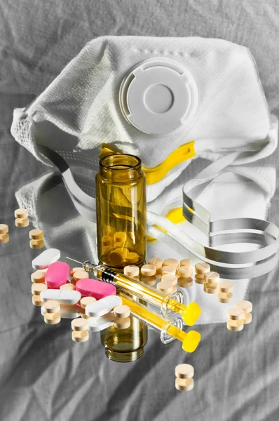 Захисна маска та пляшка ліків з таблетками та шприцом — стокове фото
