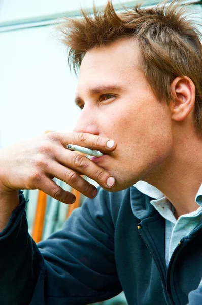 Fechar de um jovem com cigarro na boca — Fotografia de Stock
