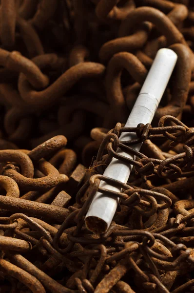 Cigarette in the bonds of a rusty chain — Stock Photo, Image