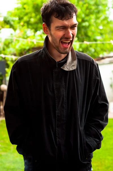 Jonge man lachen op een grap buitenshuis — Stockfoto