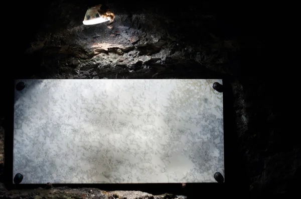 Señal de mármol iluminada por lámpara en cueva —  Fotos de Stock