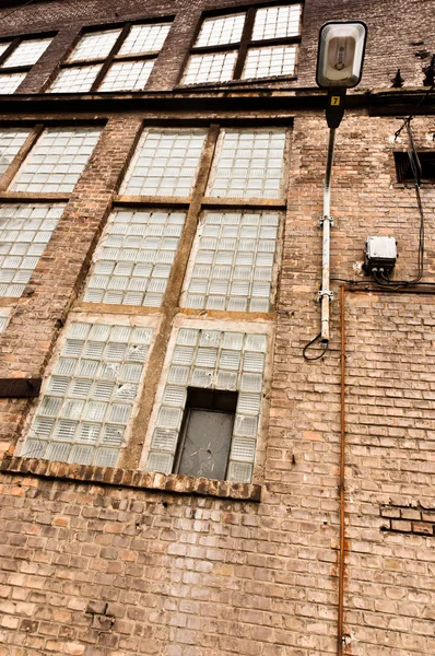 Угловой снимок заброшенного промышленного здания с кирпичной стеной — стоковое фото