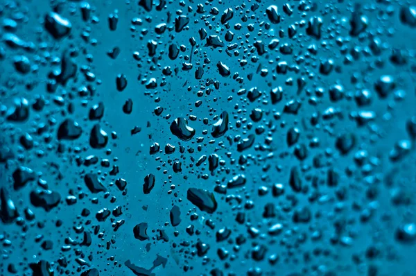 Water on blue surface with selective focus — Stock Photo, Image