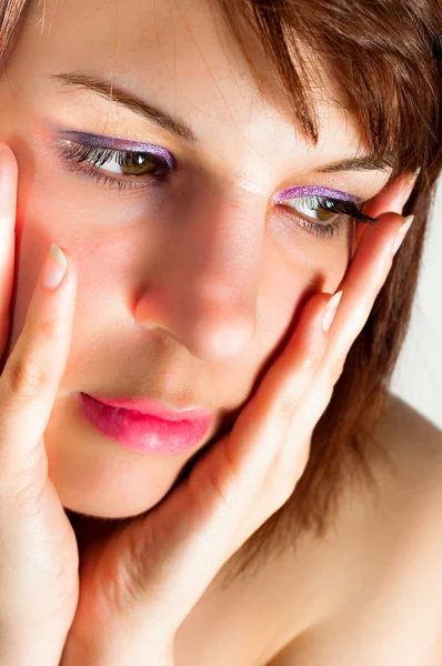 Close-up de uma jovem mulher segurando o rosto com as mãos — Fotografia de Stock