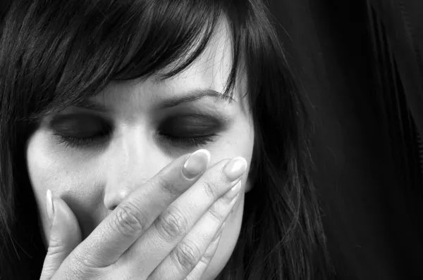 Jong meisje die betrekking hebben op haar mond met haar hand in zwart-wit — Stockfoto