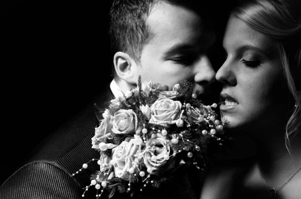 Jeune couple en tenue de mariage avec bouquet de roses — Photo