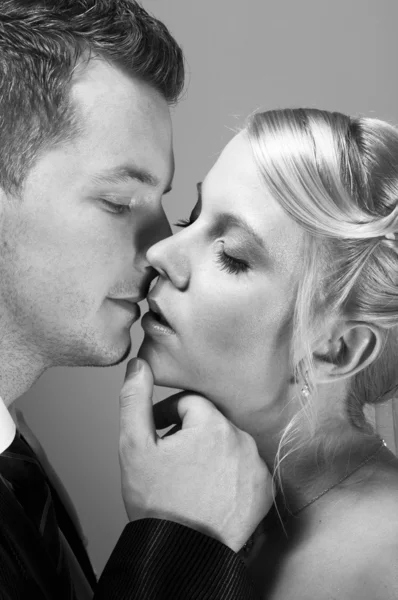 Молодая пара в свадебной одежде целуется — стоковое фото