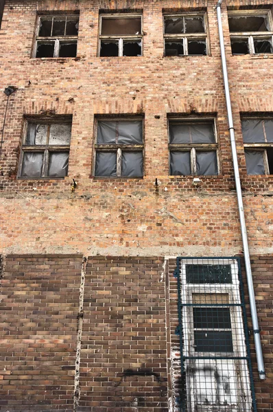 Úhlu střílel opuštěné průmyslové budovy s cihlovou zeď — Stock fotografie