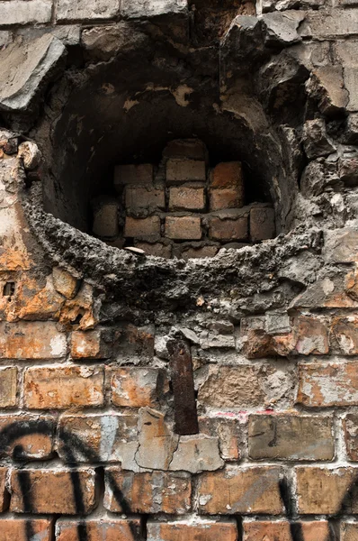 Дыра в заброшенной кирпичной стене — стоковое фото