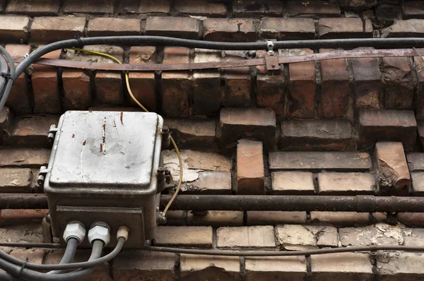Parede de tijolo velho com caixas elétricas — Fotografia de Stock